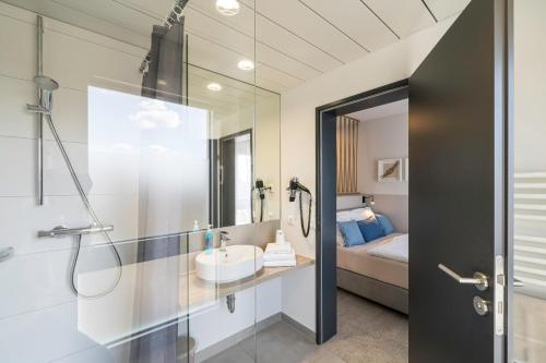a bathroom with a sink and a shower at WIROtel Warnemünde in Warnemünde