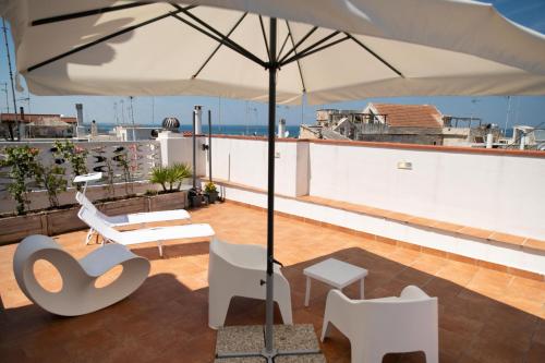 a patio with an umbrella on a roof at Old town apartment with sea view private rooftop in Giovinazzo