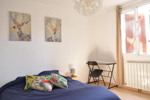 une chambre avec un lit, une table et une chaise dans l'établissement Maison RAVI, à Lectoure