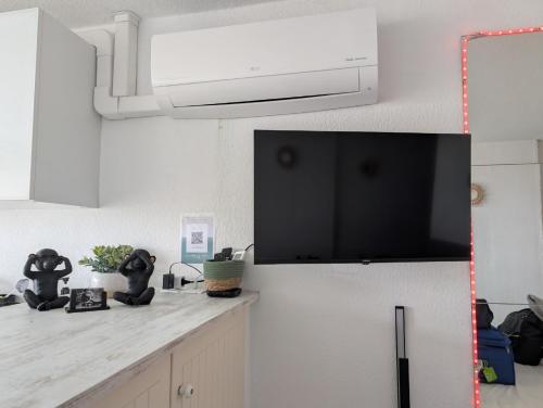 - une cuisine avec un comptoir blanc et un four micro-ondes dans l'établissement Studio avec terrasse Heliopolis, au Cap d'Agde