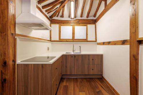 eine Küche mit Holzschränken und einer Spüle in der Unterkunft Full moon hanok - Premium stay , Open sale in Seoul