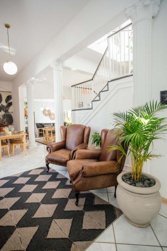 a living room with a couch and a staircase at The Palms Boutique Hotel in Hilton