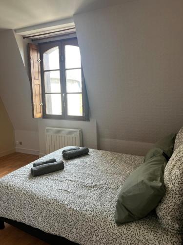 a bedroom with two towels on a bed with a window at Appartement au coeur de Saumur - Chambre climatisée in Saumur