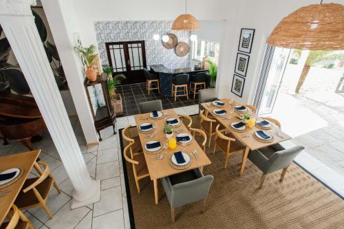 a dining room with wooden tables and chairs at The Palms Boutique Hotel in Hilton