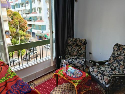 a room with two chairs and a table and a window at Gadou Rooms in Port Said