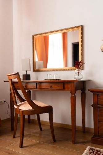 a wooden desk with a mirror and a chair at Pensiunea Cocosel in Căstău