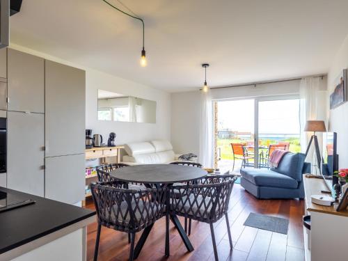 a kitchen and living room with a table and chairs at Pieds Dans L'eau Madame est Servie in Trébeurden
