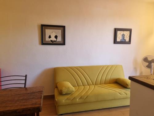 a living room with a yellow couch and a table at Agriturismo TERRANERA in Scansano