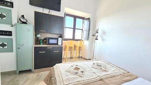 a small kitchen with a bed in a room at Casa Bakara Vejer old town in Vejer de la Frontera