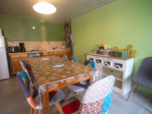une cuisine avec une table et des chaises dans une pièce dans l'établissement Le Clos du Tramaillou gite La Grand Voile pour 6 S, à Annezay