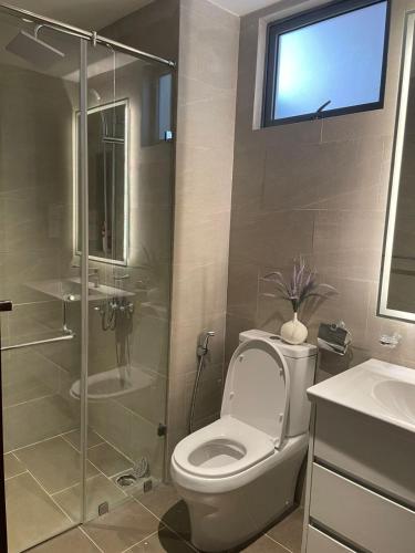 a bathroom with a toilet and a glass shower at Trizen Amber 2-Bedroom Apartment with Free WIFI in Colombo