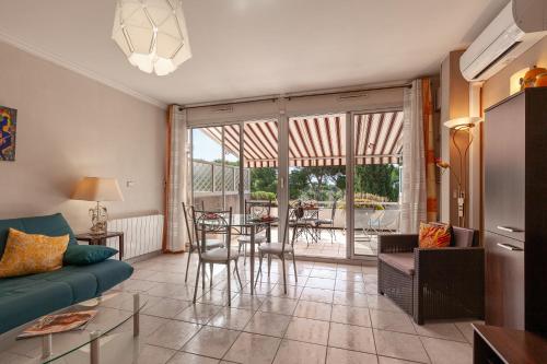 un salon avec un canapé et une table avec des chaises dans l'établissement Tres Beau T2 - 50 M - Vue Mer, à Carry-le-Rouet