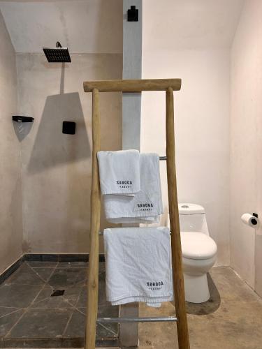 a bathroom with a towel rack with a toilet at Hostel-Island Paradise, Saboga Lodge and Villa Noelia in Panama City