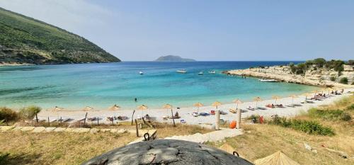 a beach with umbrellas and people on the beach at Vacanze Pushime Albania in Radhimë