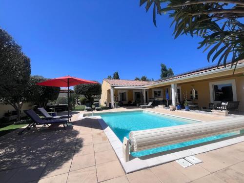 une piscine devant une maison dans l'établissement Belle villa avec piscine et spa, à Teyran