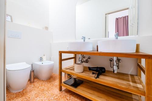 a bathroom with two sinks and a toilet at Villetta Panorama - Private Pool in Parabita