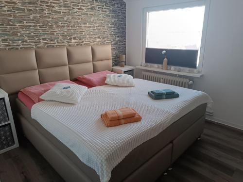 a bedroom with a bed with two towels on it at Ferienwohnung Harz Valley -Mit Fernblick in den Harz. in Goslar