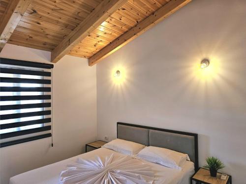 ein Schlafzimmer mit einem Bett mit zwei Lichtern an der Wand in der Unterkunft Villa Arta Apartments in Sarandë