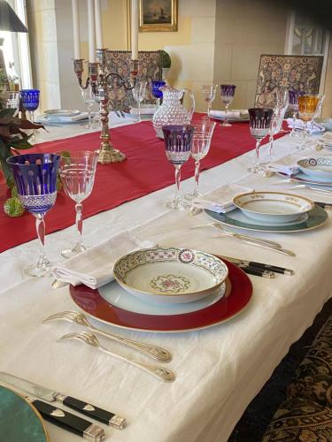 a table with plates and wine glasses on it at Château de Bouesse en Berry in Bouesse