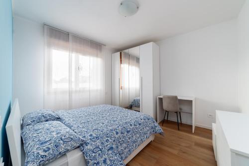 a white bedroom with a bed and a desk at La Casa Giusta Moderno Trilocale Monza Policlinico in Monza
