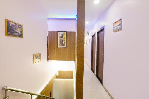 a hallway with stairs and a wooden door at FabExpress Tawakkal - Nr Phoenix Mall Kurla in Mumbai
