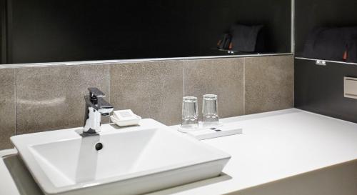 a bathroom with a white sink and a mirror at Maison Glad Jeju in Jeju