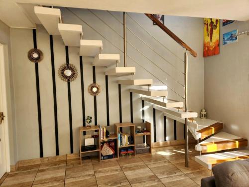 a living room with a staircase in a house at Knoll at Oaklands - Two Bedroom APT Knysna Retreat! in Knysna
