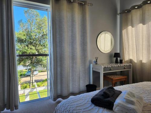 a bedroom with a bed and a window with a view at Knoll at Oaklands - Two Bedroom APT Knysna Retreat! in Knysna