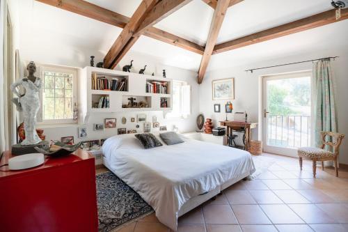 - une chambre avec un grand lit blanc et des étagères dans l'établissement Bastide Provençale avec piscine, à Aix-en-Provence