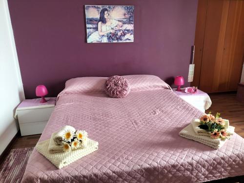 a bedroom with a pink bed with flowers on it at Fronte mare rooms in Palermo