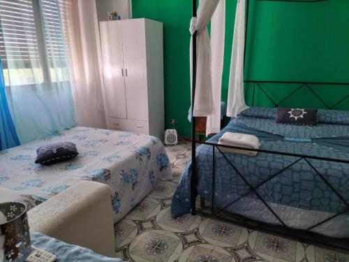 a bedroom with a bed and a green wall at Fronte mare rooms in Palermo