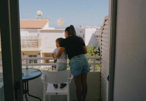 a woman and a child standing on a balcony at Kumba in Nea Chora in Chania Town
