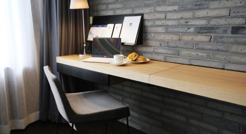 a desk with a laptop and a plate of food at Maison Glad Jeju in Jeju