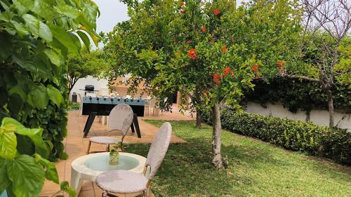 a garden with a tree and chairs and a piano at Small Luxury apartments Pool and sea view - Stella Del Mare in Fontane Bianche
