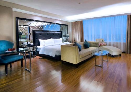a hotel room with a bed and a couch at The Alana Hotel & Convention Center Solo by ASTON in Solo