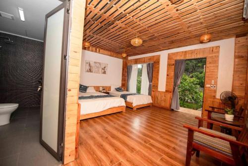 a bedroom with two beds and a bathroom at Hang Mua Luxury Homestay in Xuân Sơn