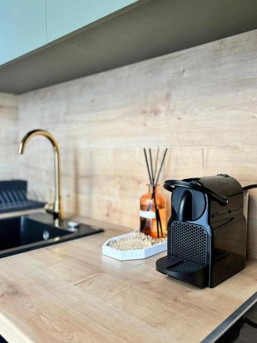a kitchen counter with a coffee maker on a counter top at TINTURA by BAST - Wanna, Antresola, OFF Piotrkowska, EC1 ,Stajnia Jednorożca, Winda, Parking na Terenie, Orientarium, Hopa Lupa, ATLAS ARENA in Łódź