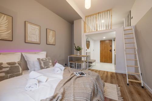 a bedroom with a white bed and a ladder at TINTURA by BAST - Wanna, Antresola, OFF Piotrkowska, EC1 ,Stajnia Jednorożca, Winda, Parking na Terenie, Orientarium, Hopa Lupa, ATLAS ARENA in Łódź