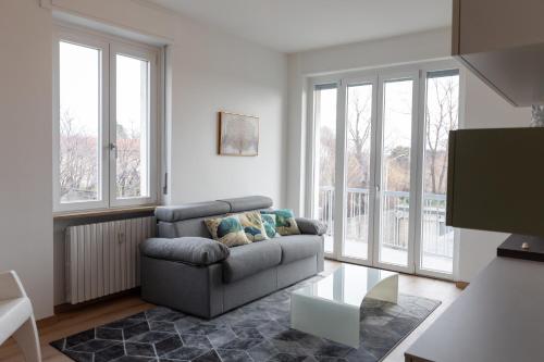 a living room with a couch and some windows at Elegant Apartment Biella, near Hospital ! in Gaglianico