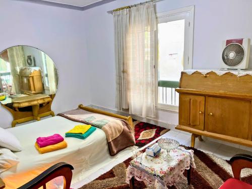 a bedroom with a bed and a mirror and a table at Gadou Rooms -Private & Shared Stays in Port Said Best Location in Port Said