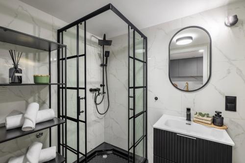 a bathroom with a shower and a sink and a mirror at TINTURA by BAST - Wanna, Antresola, OFF Piotrkowska, EC1 ,Stajnia Jednorożca, Winda, Parking na Terenie, Orientarium, Hopa Lupa, ATLAS ARENA in Łódź