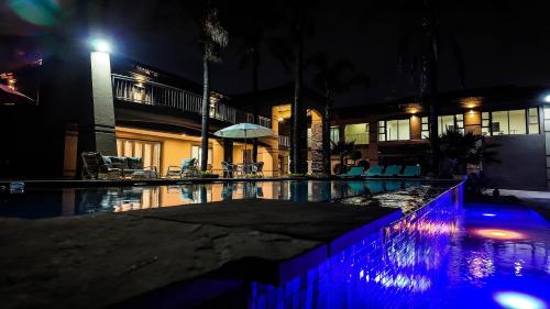 a swimming pool at night with a building at Ondjo Yetu in Benoni