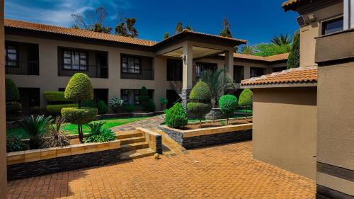 a house with a courtyard with trees and bushes at Ondjo Yetu in Benoni