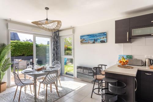 une cuisine et un salon avec une table et des chaises dans l'établissement Ti Cosy - 7min de la Plage, à Fréhel