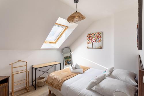 Un dormitorio con una cama y una claraboya. en Ti Cosy - 7min de la Plage, en Fréhel