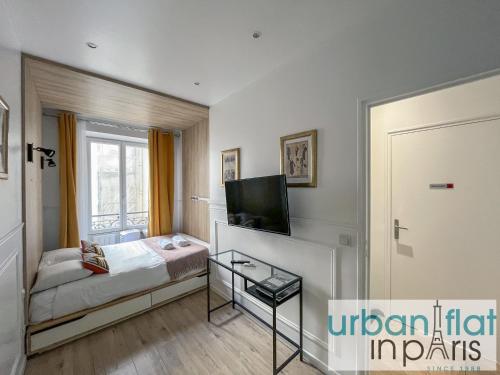 une chambre avec un lit, une télévision et une fenêtre dans l'établissement Urban Flat 80 - Paris Cinema Sebastopol, à Paris
