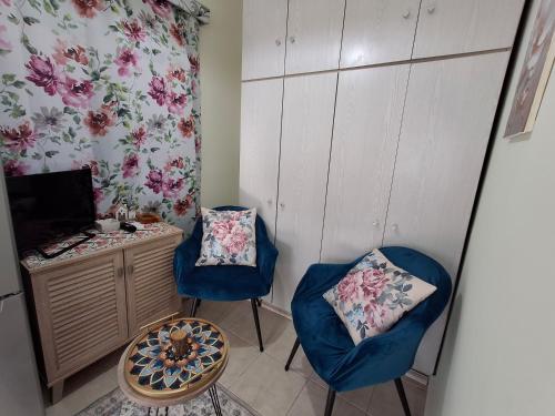 a room with two chairs and a desk and a television at Lovely House in Mytilini