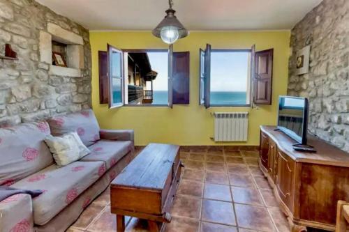 a living room with a couch and a tv at La casina del Penayu in Lastres
