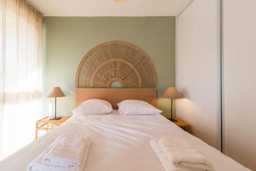 a bedroom with a large white bed with two pillows at Magnifique appartement plage de Trestraou in Perros-Guirec