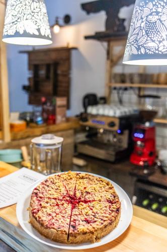 a pizza sitting on a plate on a table at Minifaktúra Loft Apartman & Reggeliző és Ételbár in Szokolya